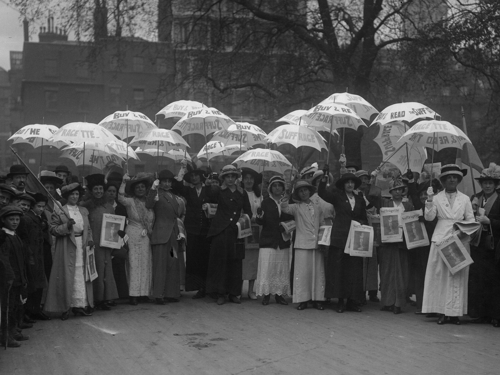 Suffragettes holding white sunshades advertising their newspaper 'Suffragette' in 1914.
