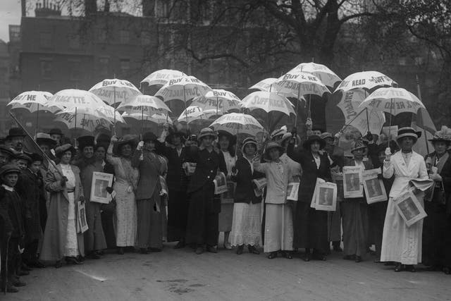 Suffragettes holding white sunshades advertising their newspaper 'Suffragette' in 1914.