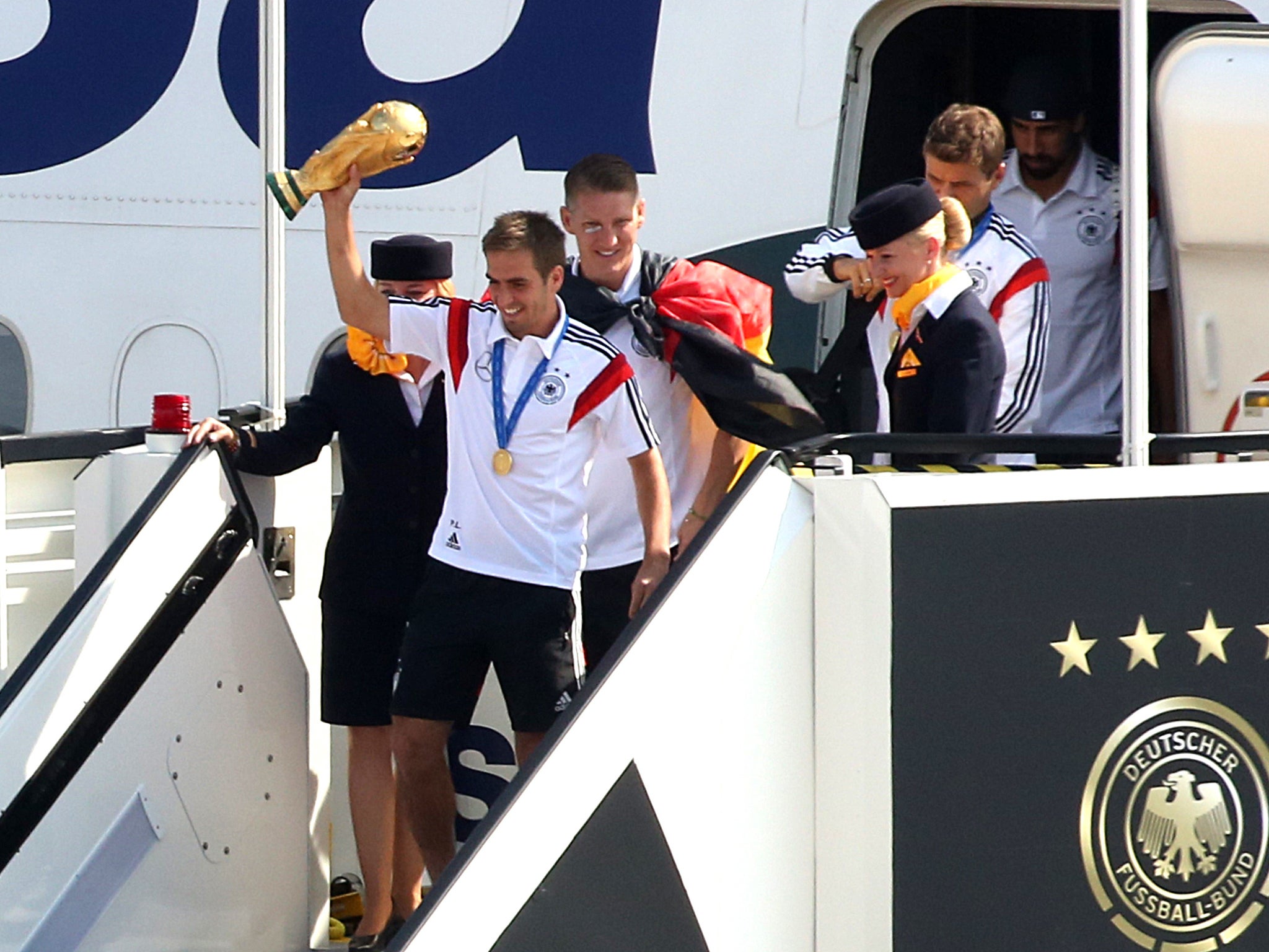 Philipp Lahm alights the plane with the World Cup