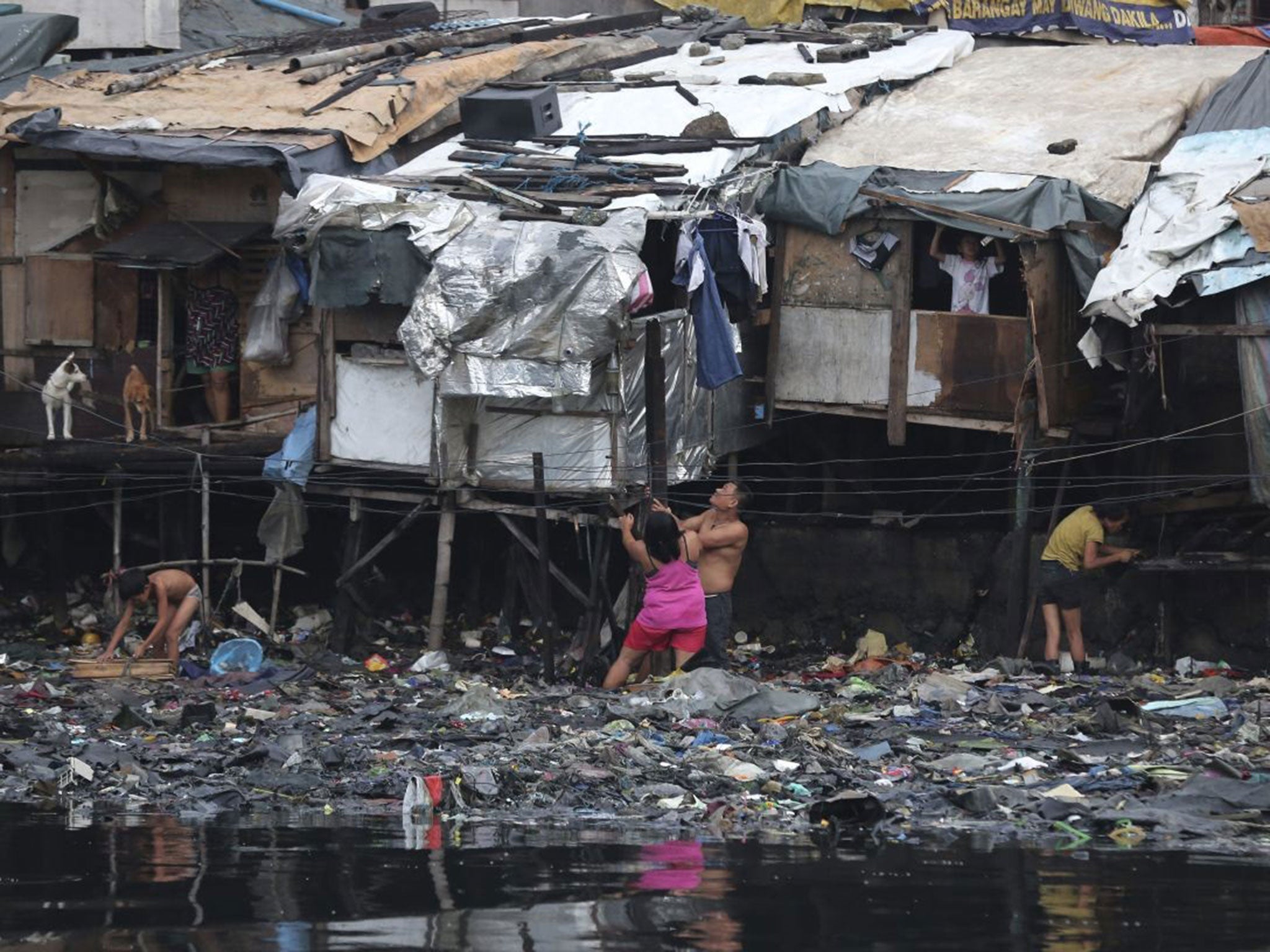 Residents strengthen their homes built on stilts as they brace for incoming Typhoon Rammasun, beside Manila's bay, Philippines on Tuesday, July 15, 2014.