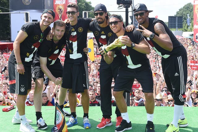 Benedikt Hoewedes, Per Mertesacker, Mesut Oezil, Sami Khedira, Lukas Podolski and Jerome Boateng pose with the World Cup trophy during the celebrations in Berlin