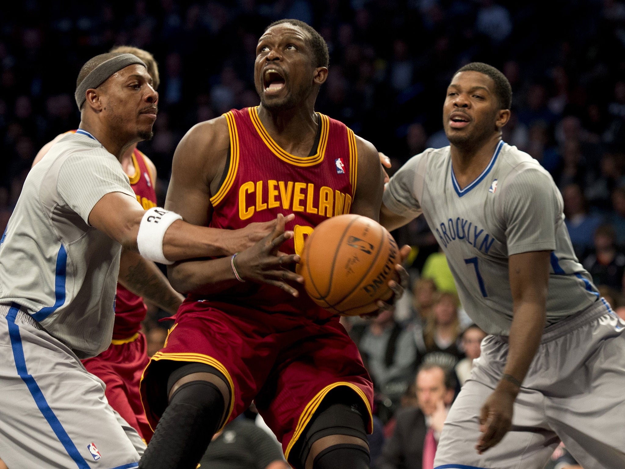 Cleveland Cavaliers Luol Deng (C) drives between Brooklyn Nets Paul Pierce and Joe Johnson during their NBA game March 28, 2014 at the Barclay Center in New York.