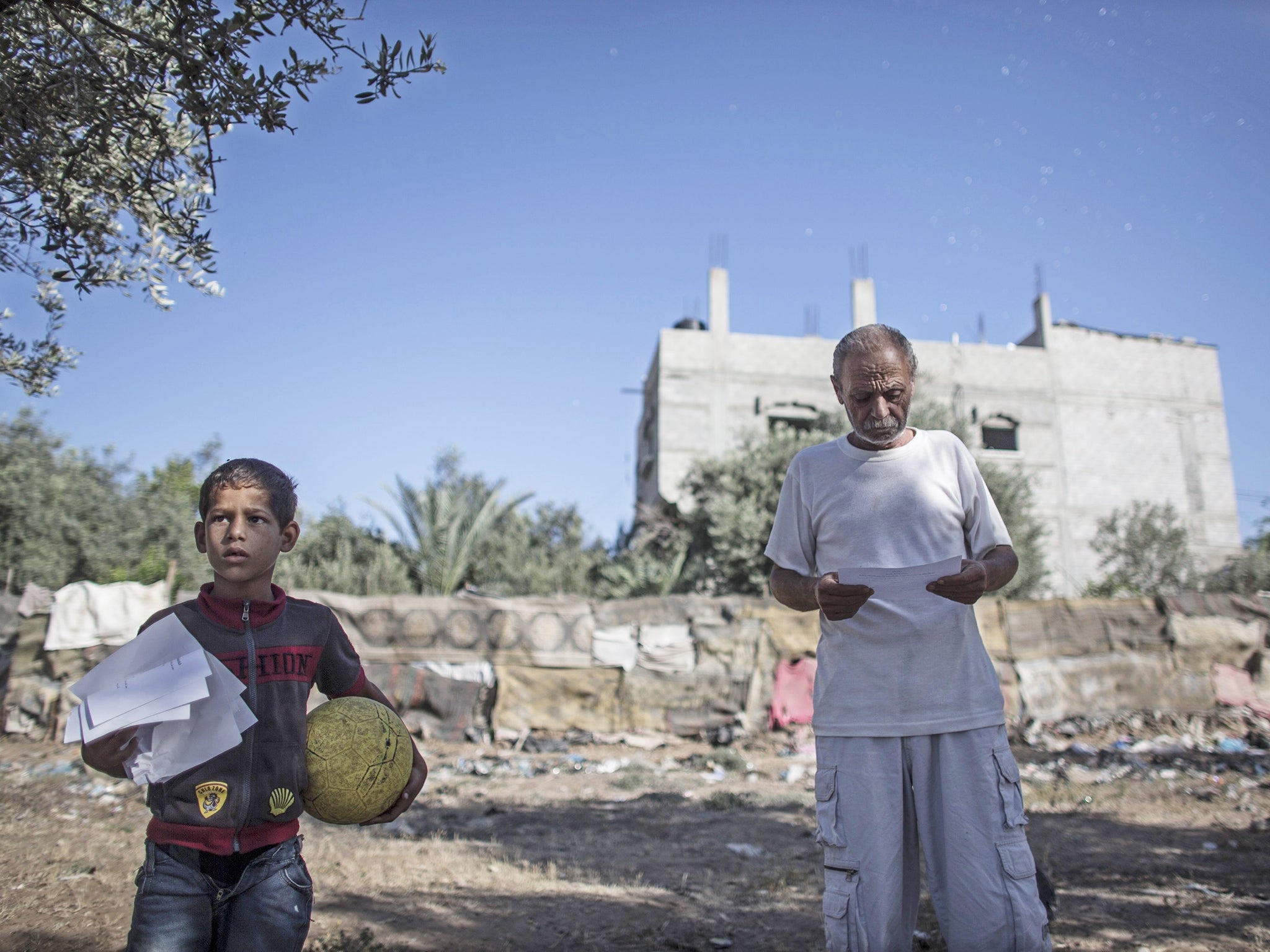 A Palestinian man reads a leaflet dropped by Israeli Defense Forces over the Shuja'iyya neighbourhood in east Gaza. The paper says residents of the area are supposed to leave the area immediately and seek shelter in the center of Gaza City before the Isra