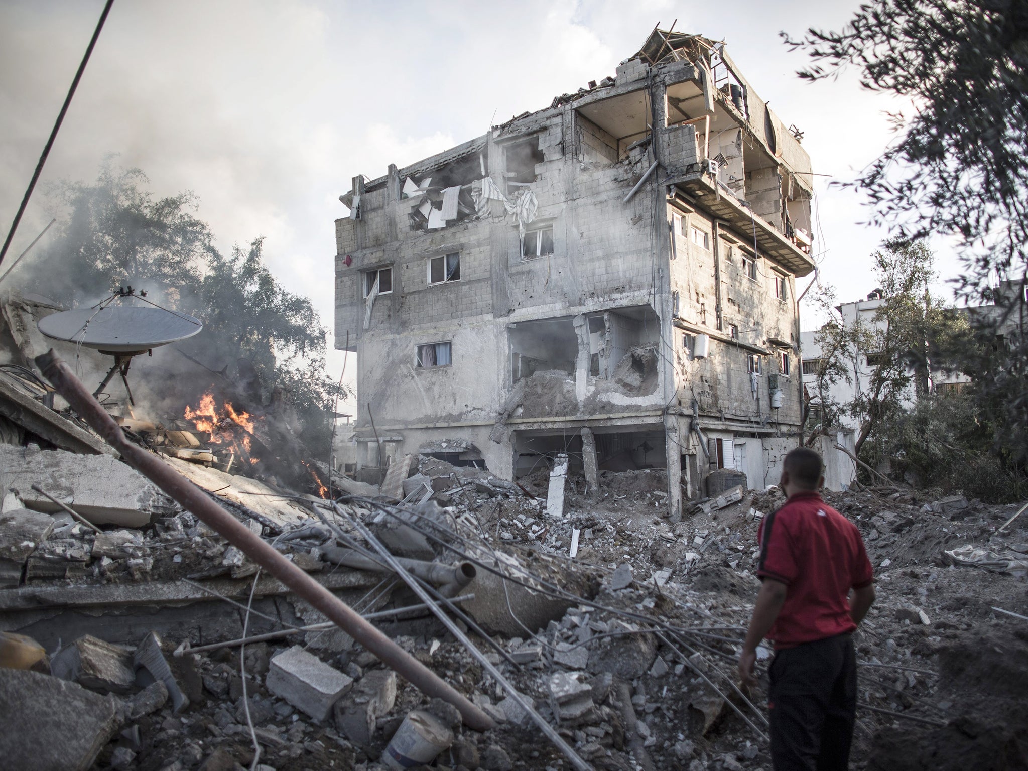 A Palestinian man looks at a house destroyed by Israeli Defense Forces during an overnight air strike in Gaza City