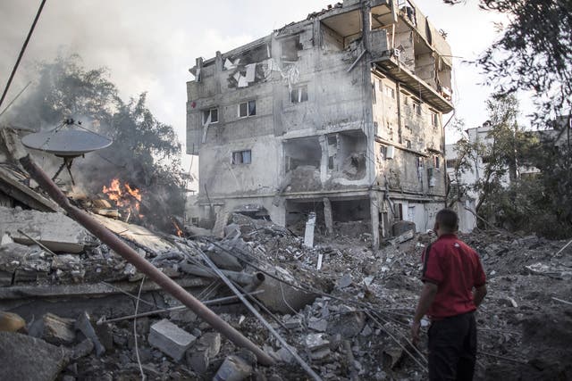 A Palestinian man looks at a house destroyed by Israeli Defense Forces during an overnight air strike in Gaza City