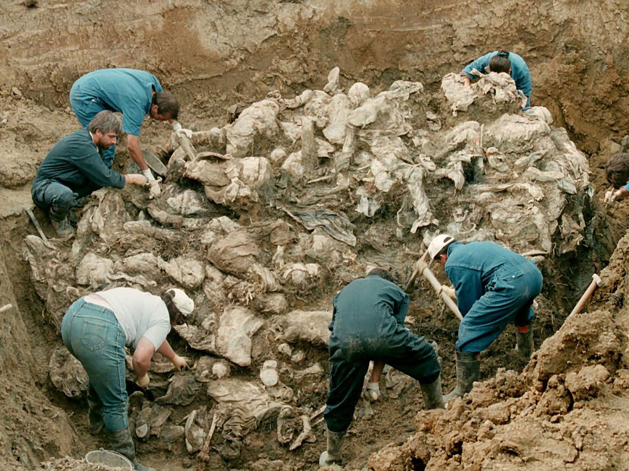 Forensic experts from the International war crimes tribunal in the Hague work on a pile of partly decomposed bodies thought to be some of the 7000 men who went missing from Srebrenica (Getty)