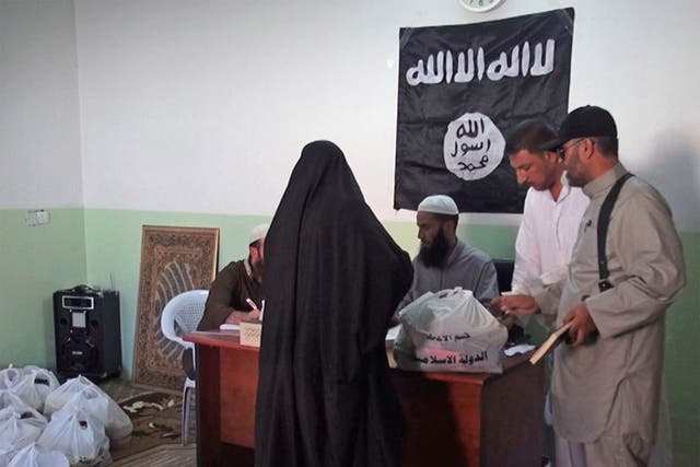A woman collecting aid administered by Isis in Syria