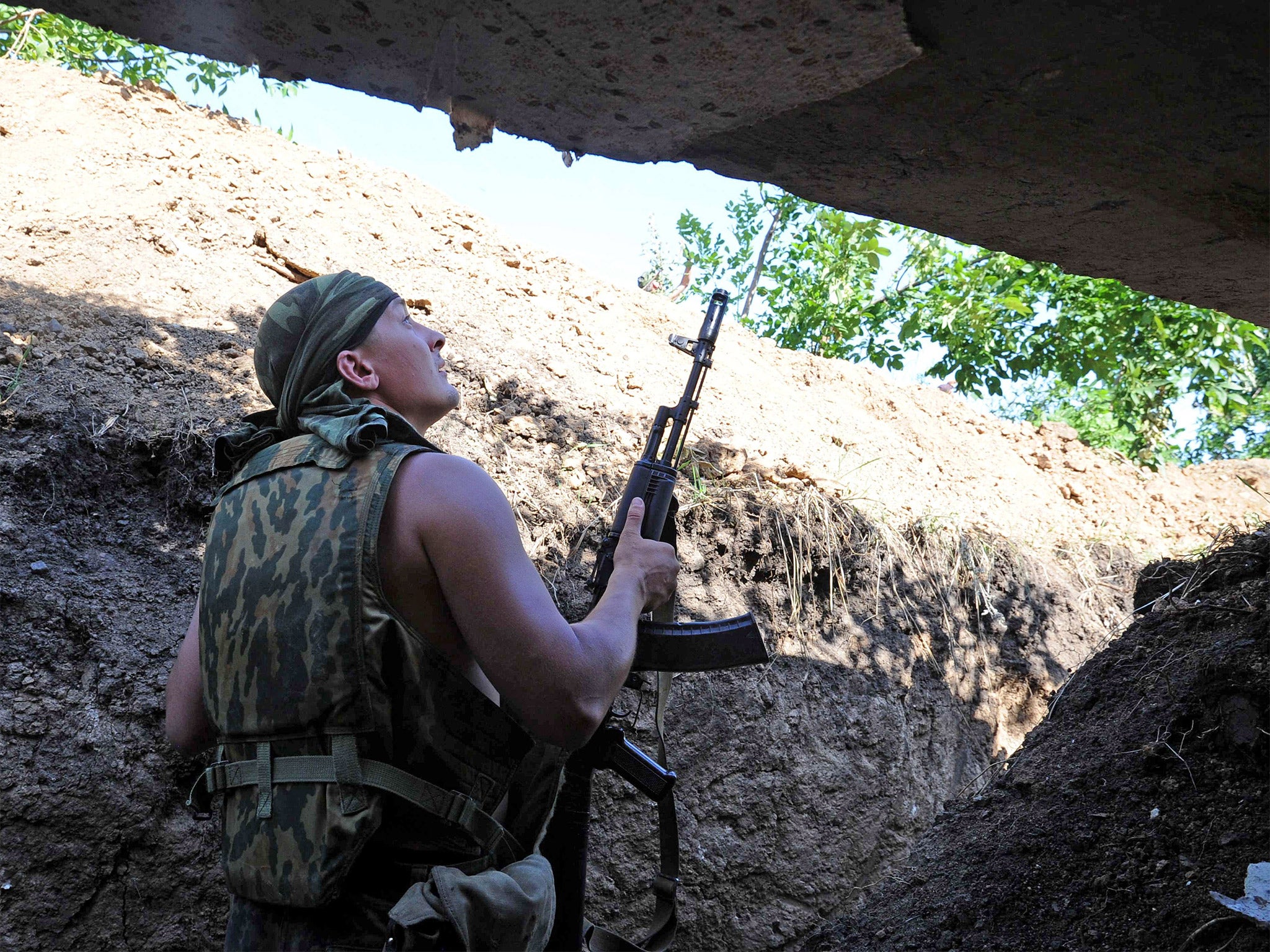A pro-Russia militant stands in a trench as he takes shelter from bombing by a Ukrainian army plane near the town of Marynivka, 100 km east of Donetsk