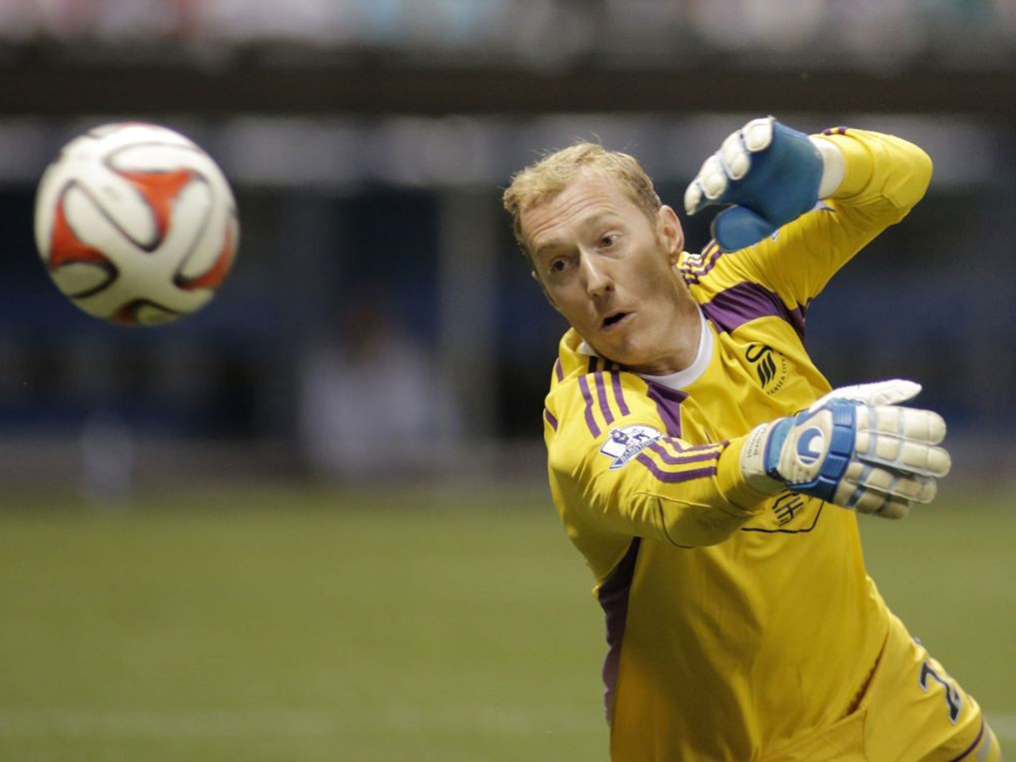 Swansea City goalie Gerhard Tremmel attempts to block a shot on goal from Chivas De Guadalajara during the second half of a International League soccer match at Miller Park Wednesday, July 16, 2014, in Milwaukee.
