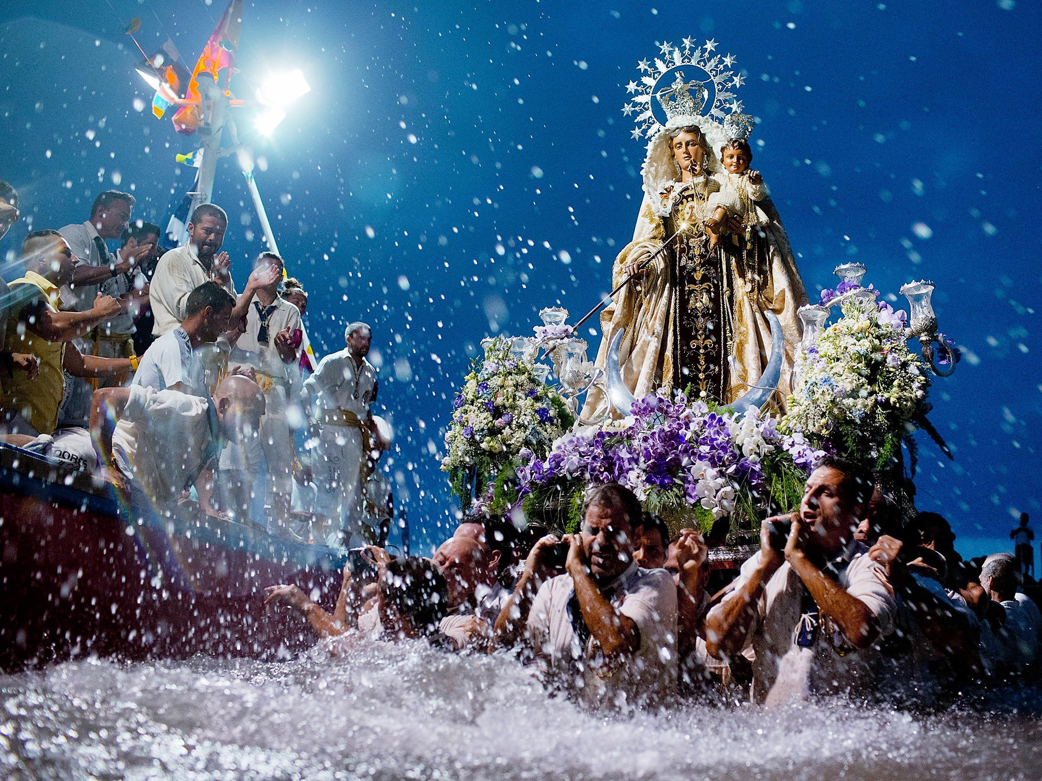 Carriers of the Great God Power brotherhood unload Virgen del Carmen statue after its journey at Puerto de la Cruz dock on the Canary island of Tenerife