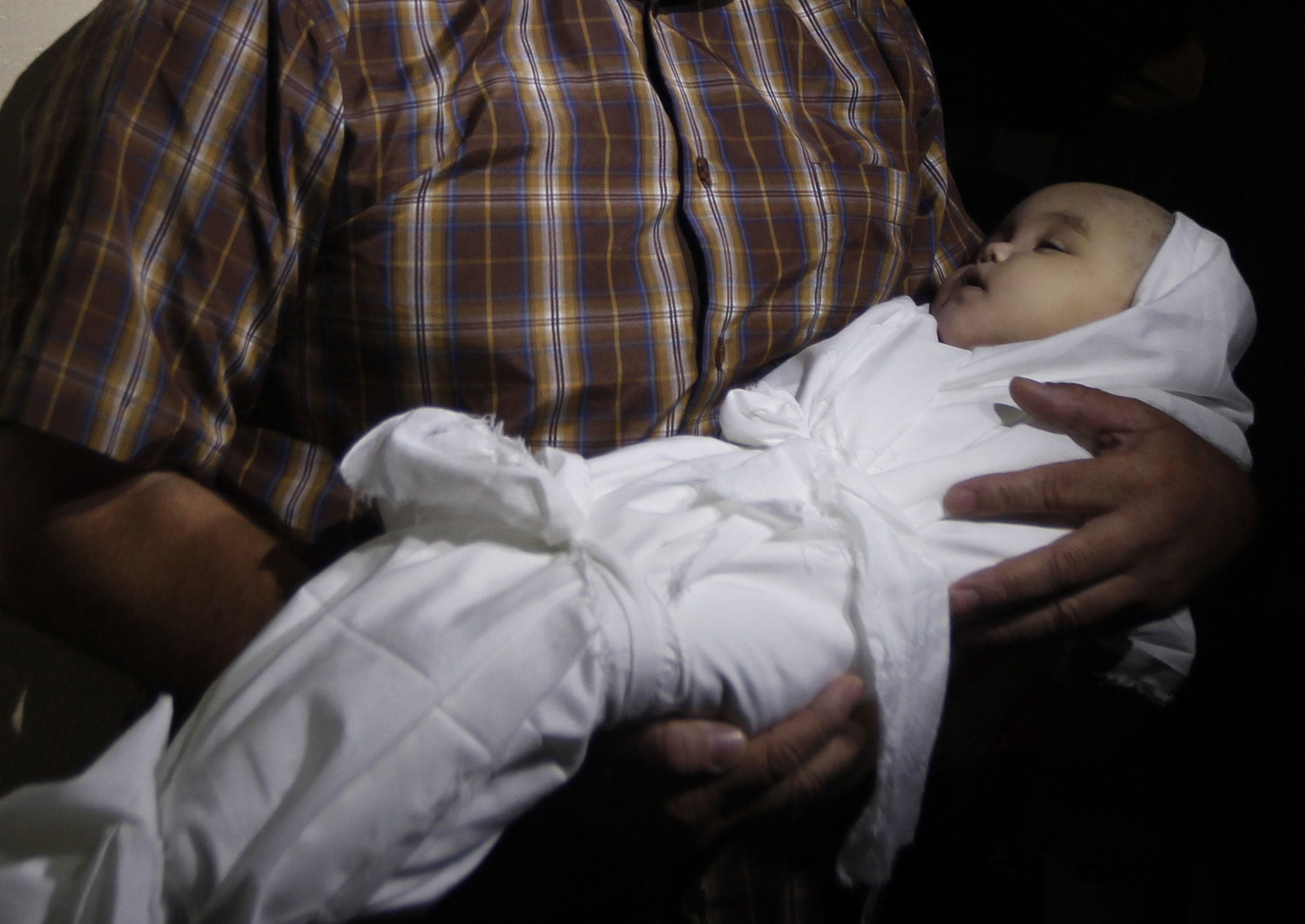 A Palestinian mourner carries the body of five-month-old girl Lama al-Satri after she was killed in an Israeli air strike the previous day, during her funeral in Rafah in the southern Gaza Strip