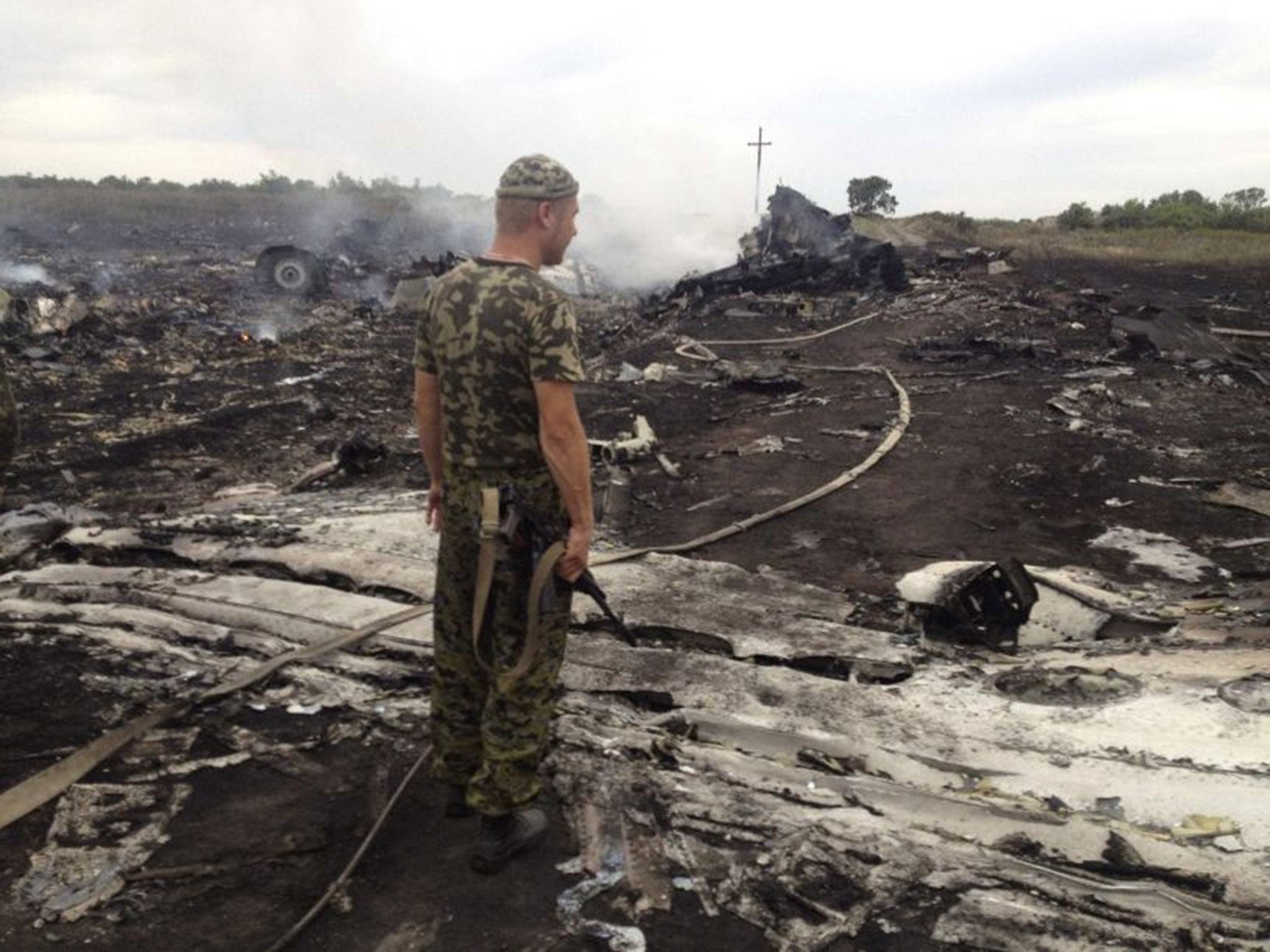 An armed pro-Russian separatist stands at a site of a Malaysia Airlines Boeing 777 plane crash in the settlement of Grabovo in the Donetsk region of Ukraine