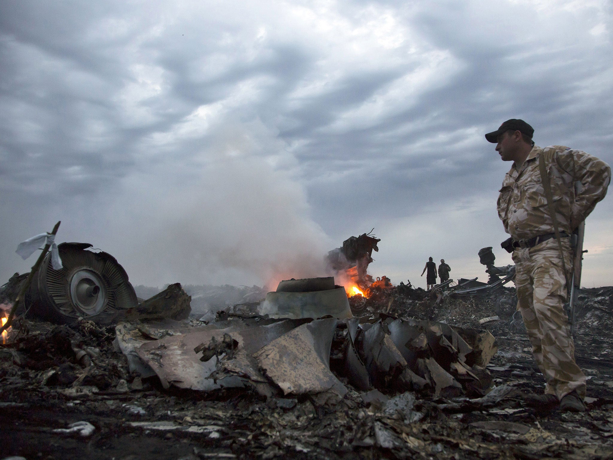 People walk amongst the debris, at the crash site of a passenger plane in Ukraine