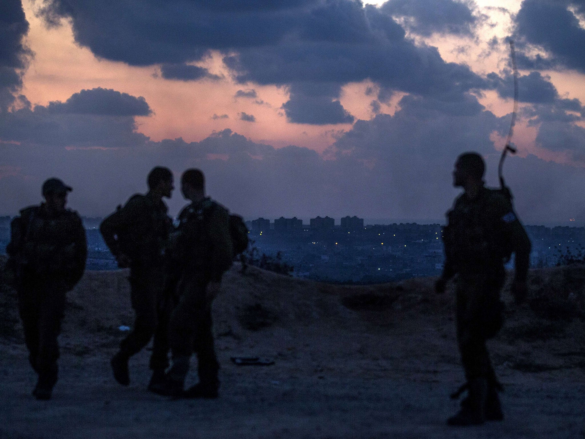 Israeli soldiers stand near the southern Israeli border with the Gaza Strip