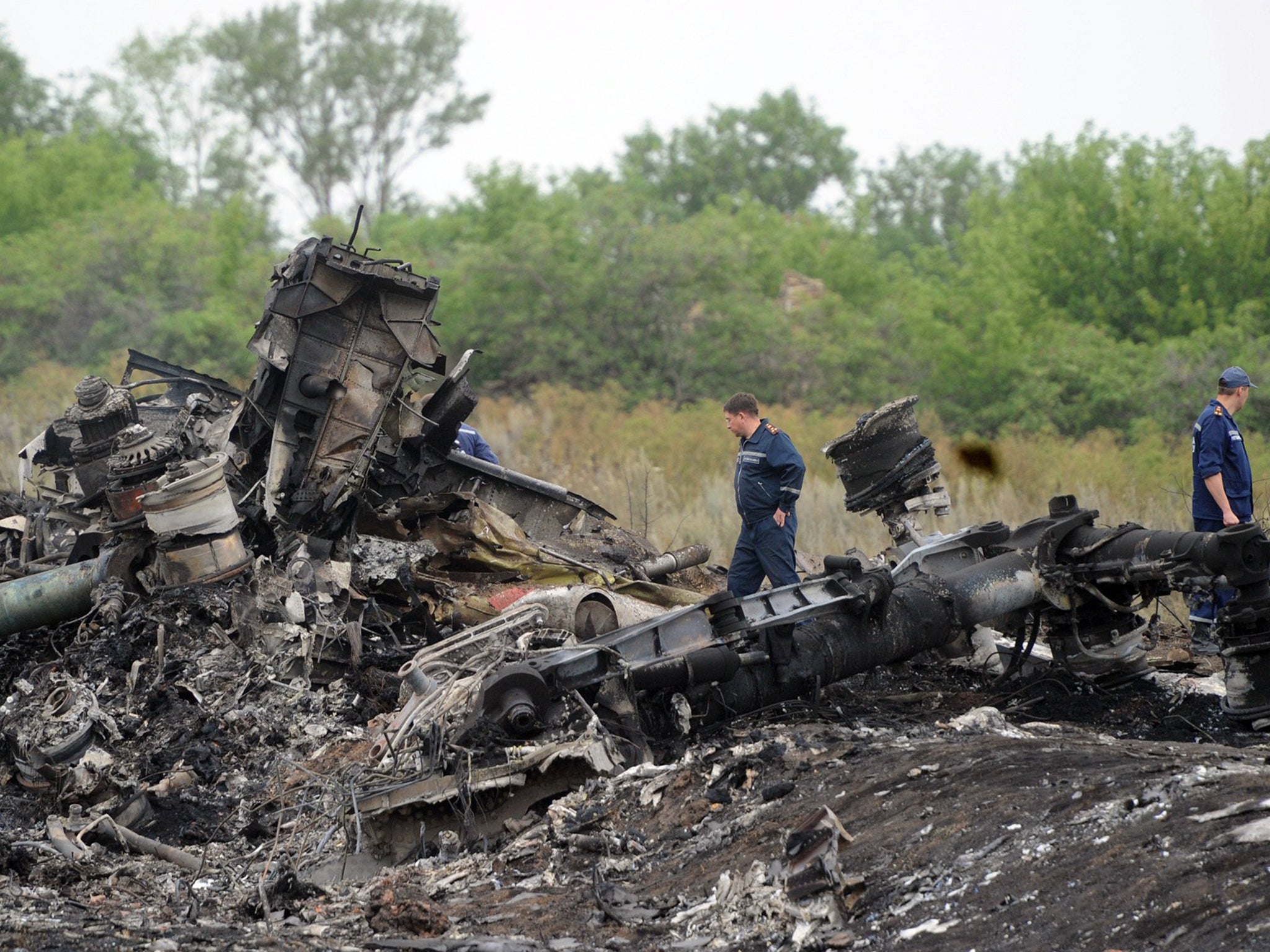 Rescuers stand on the site of the crash of a Malaysian airliner near the town of Shaktarsk, in rebel-held east Ukraine