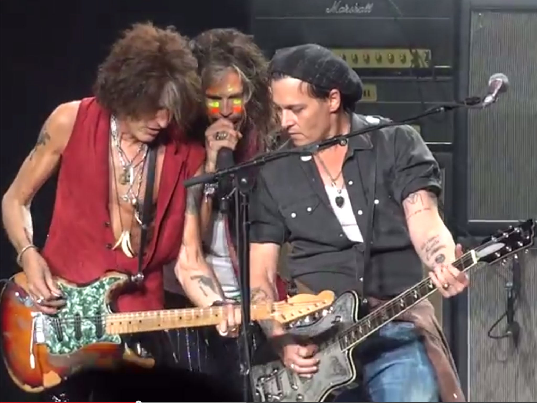 Johnny Depp (R) plays guitar with Aerosmith on stage in Boston