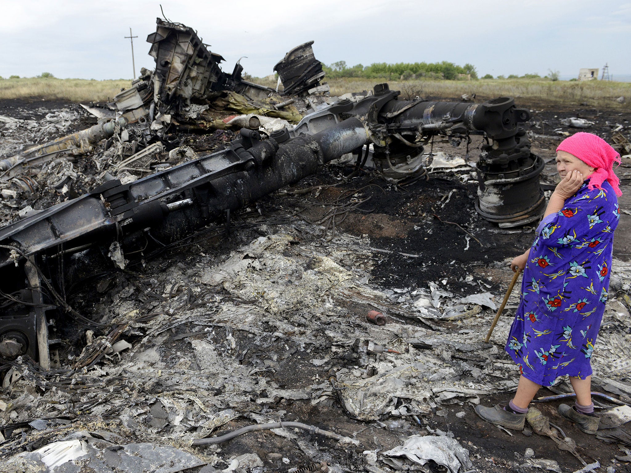 A local resident stands among the wreckage at the site of the crash