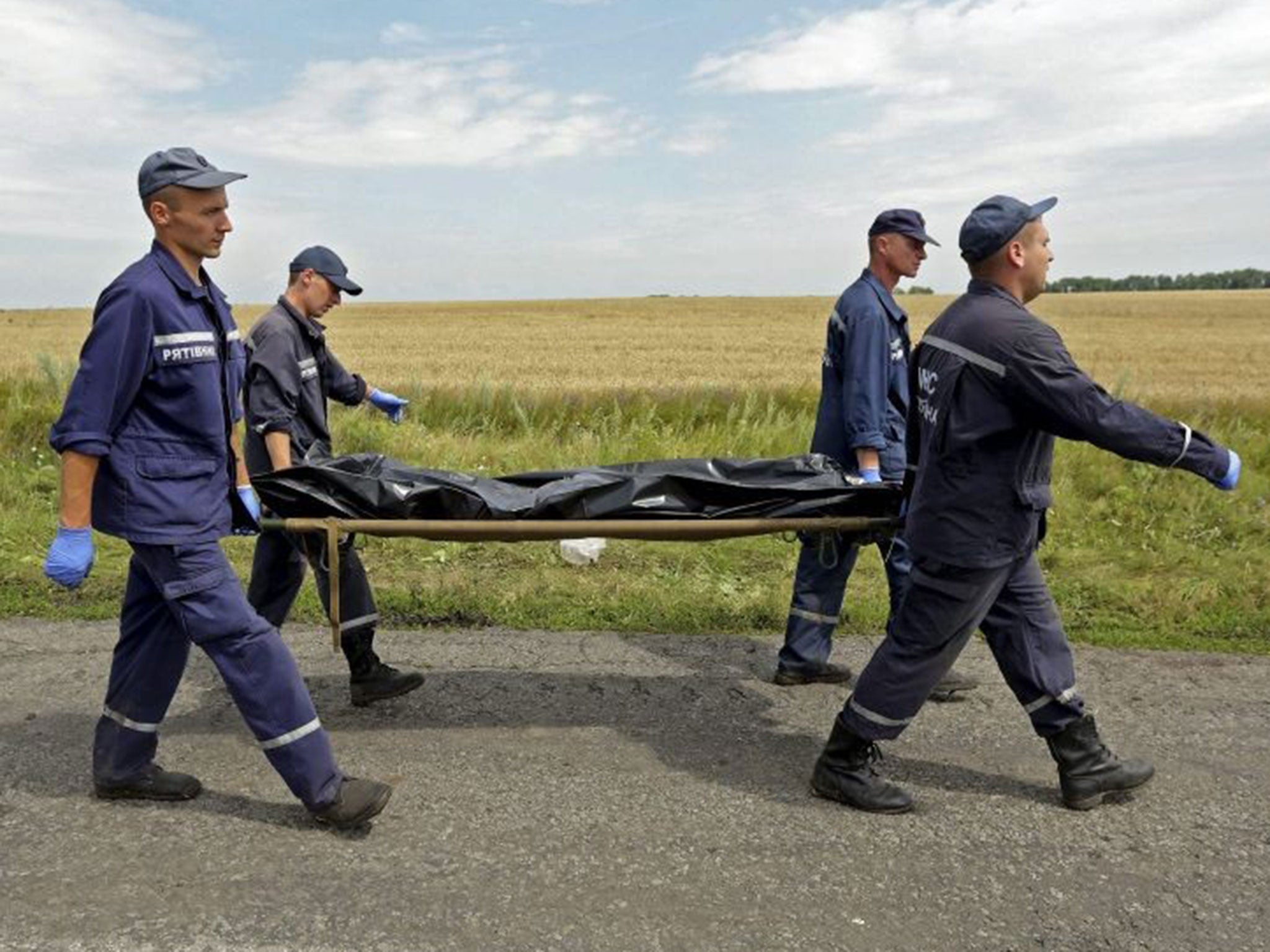 Men carry a stretcher with a bodybag at the crash site