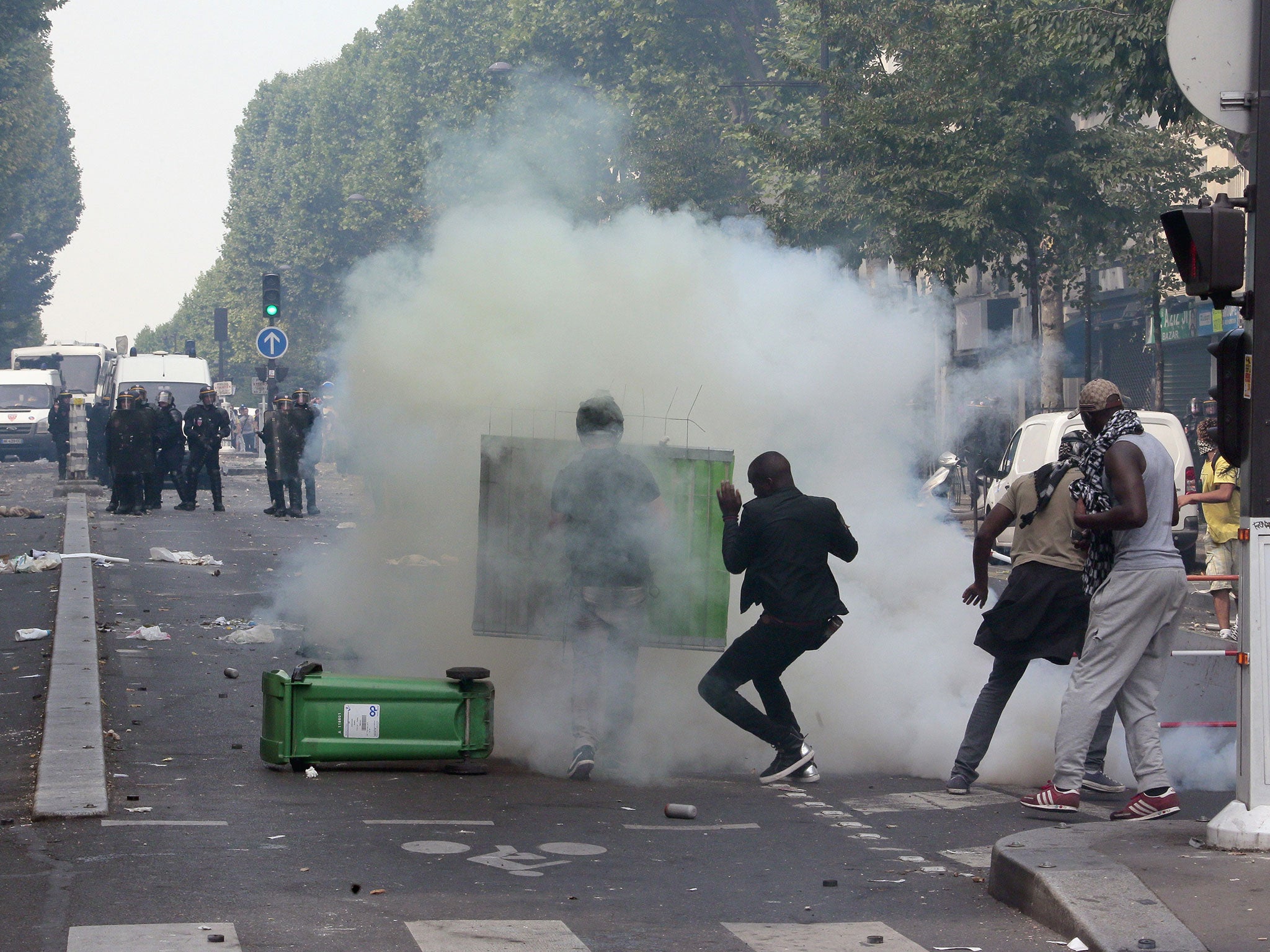 Protesters clash with riot police near the Barbes-Rochechouart aerial metro station