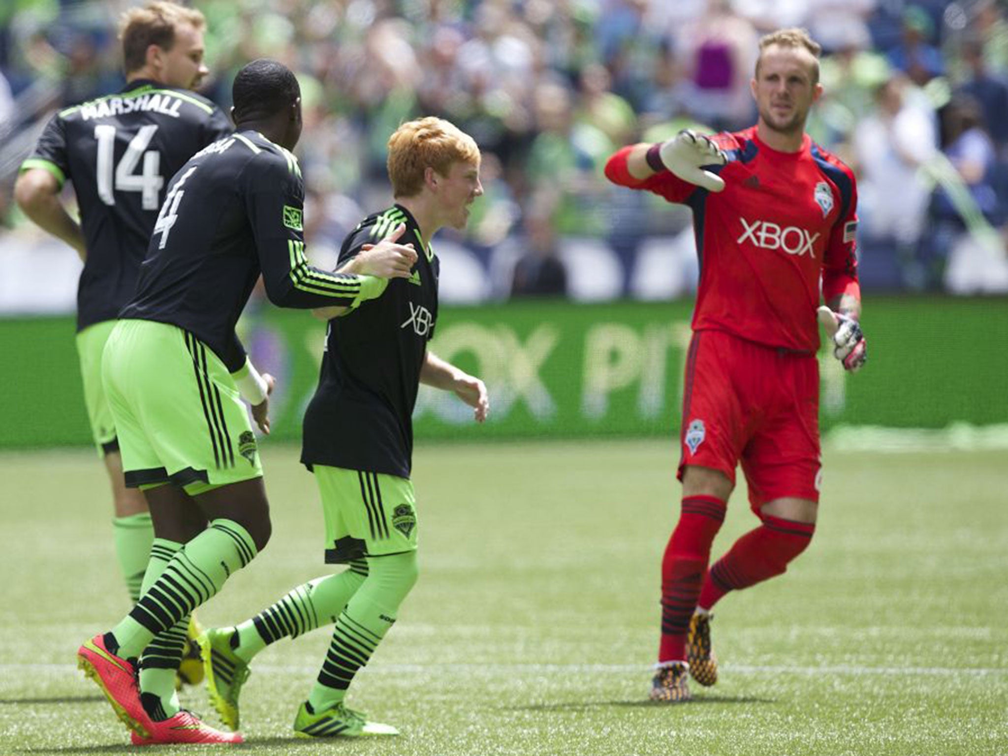 Seattle Sounders' Xander Bailey, second from right, is congratulated by teammates Chad Marshall (14), Jalil Anibaba, second from left, and Stefan Frei after scoring a ceremonial first goal against Tottenham Hotspur