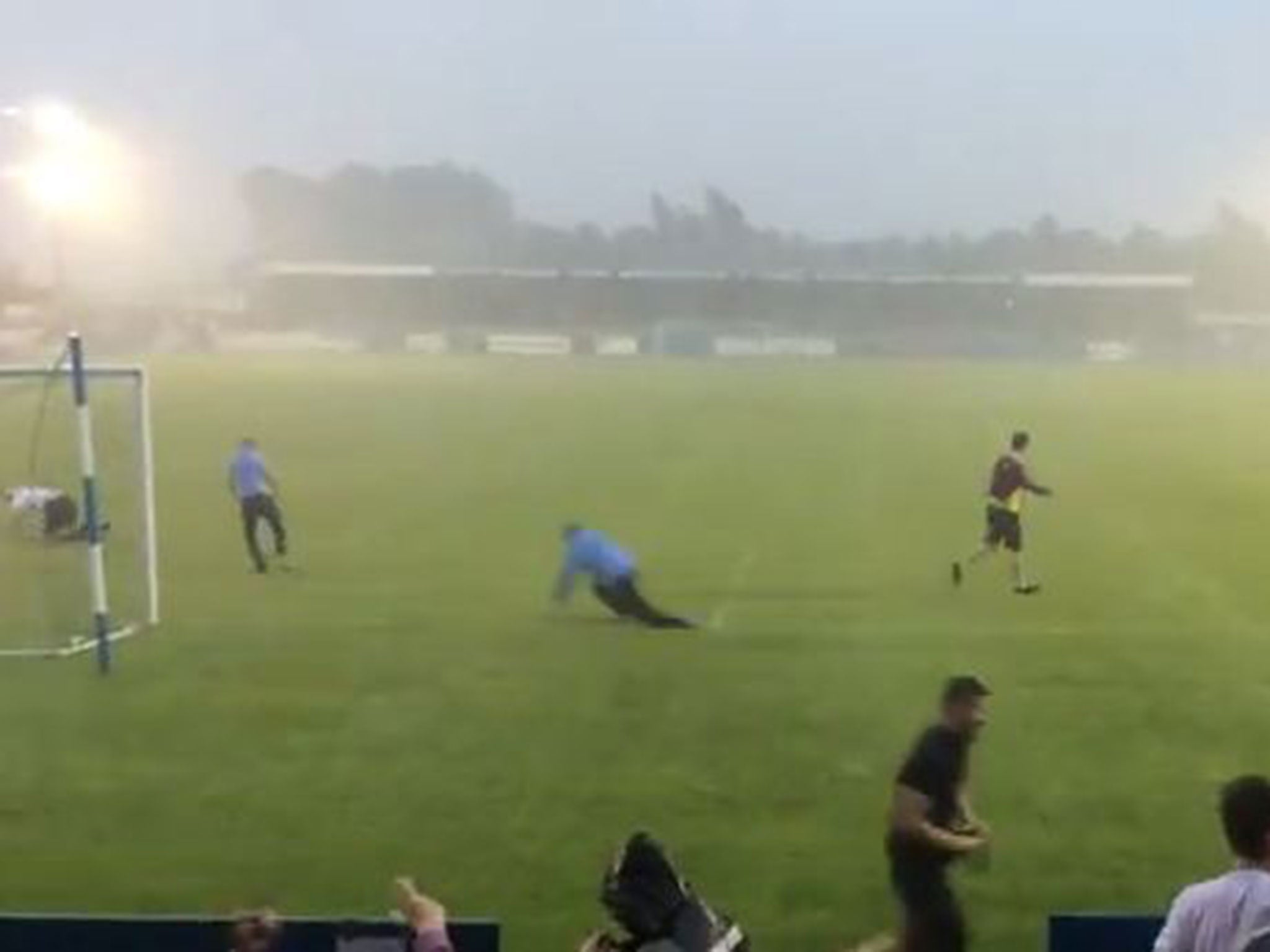 Coventry City fans do Klinsmann dives in during torrential rain after the match against Nuneaton Town was abandoned