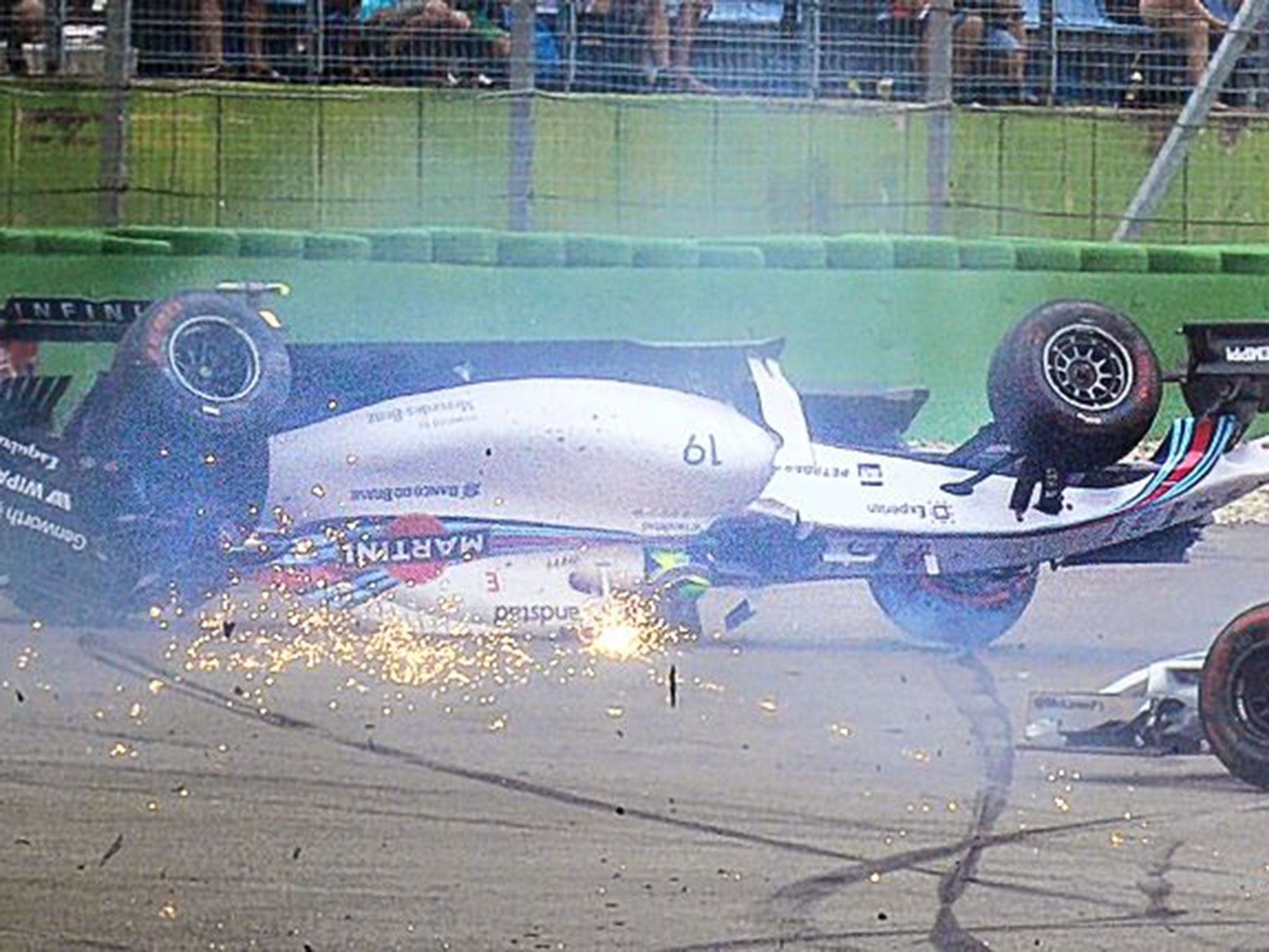 Felipe Massa’s Williams ends upside down after colliding with Kevin Magnussen’s McLaren at the first corner