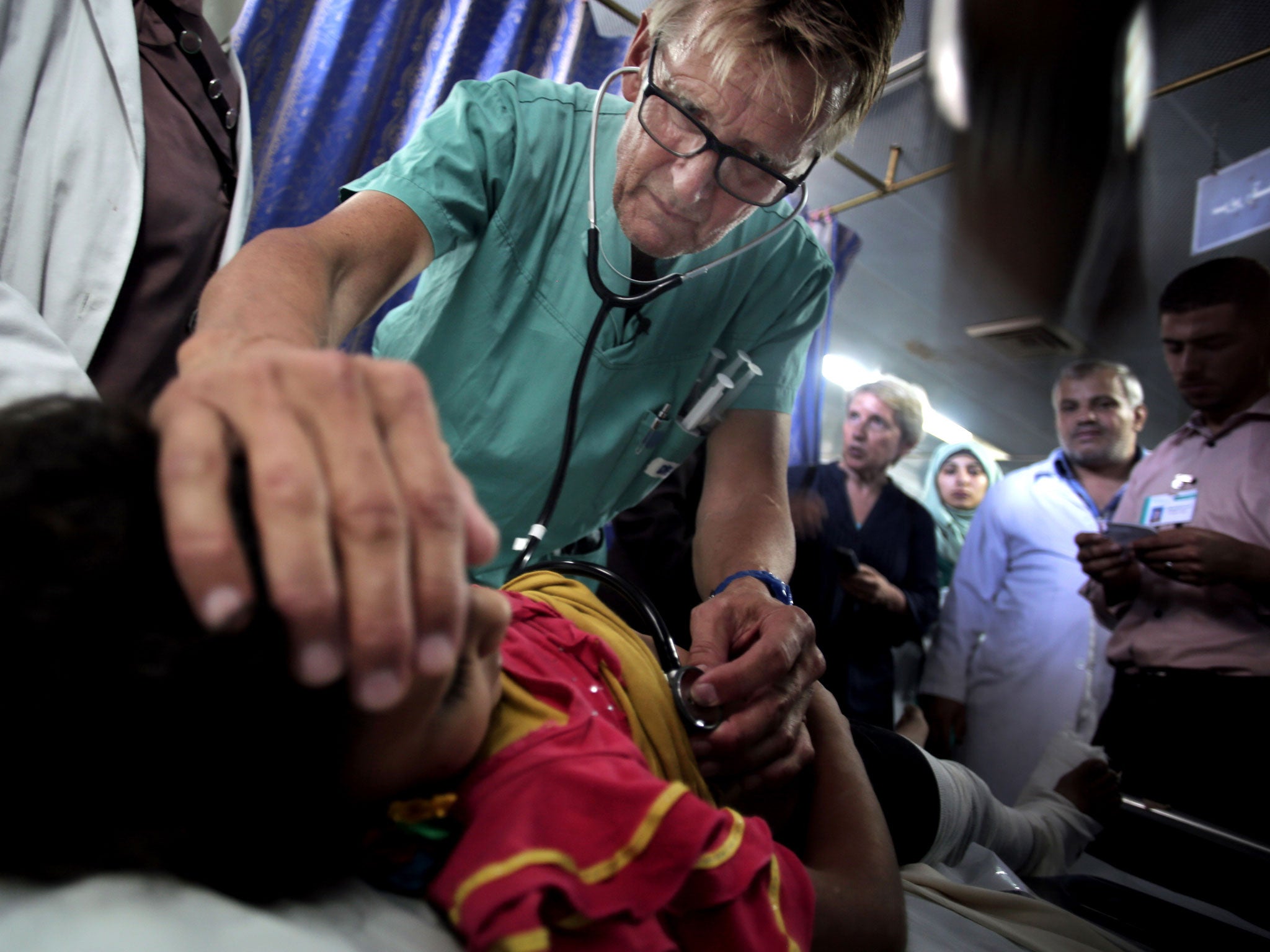 Mads Gilbert, a Norwegian doctor who is volunteering at Shifa, treats a Palestinian girl at the emergency room