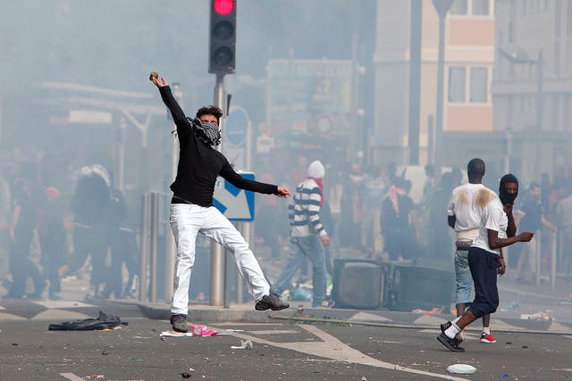 A rioter throws a stone towards riot police following a pro-Palestinians demonstration, in Sarcelles, north of Paris 