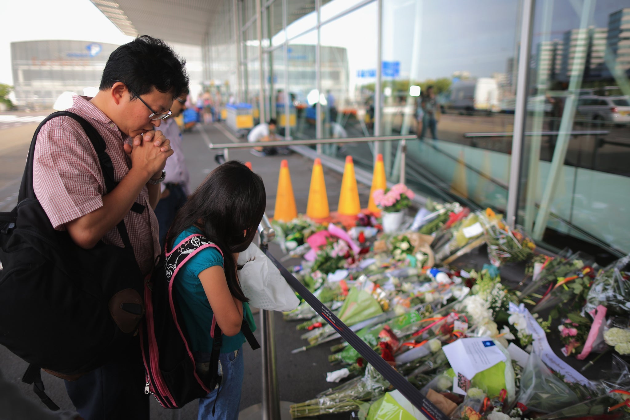 Mourners pray at the entrance to Schiphol Airport, Amsterdam