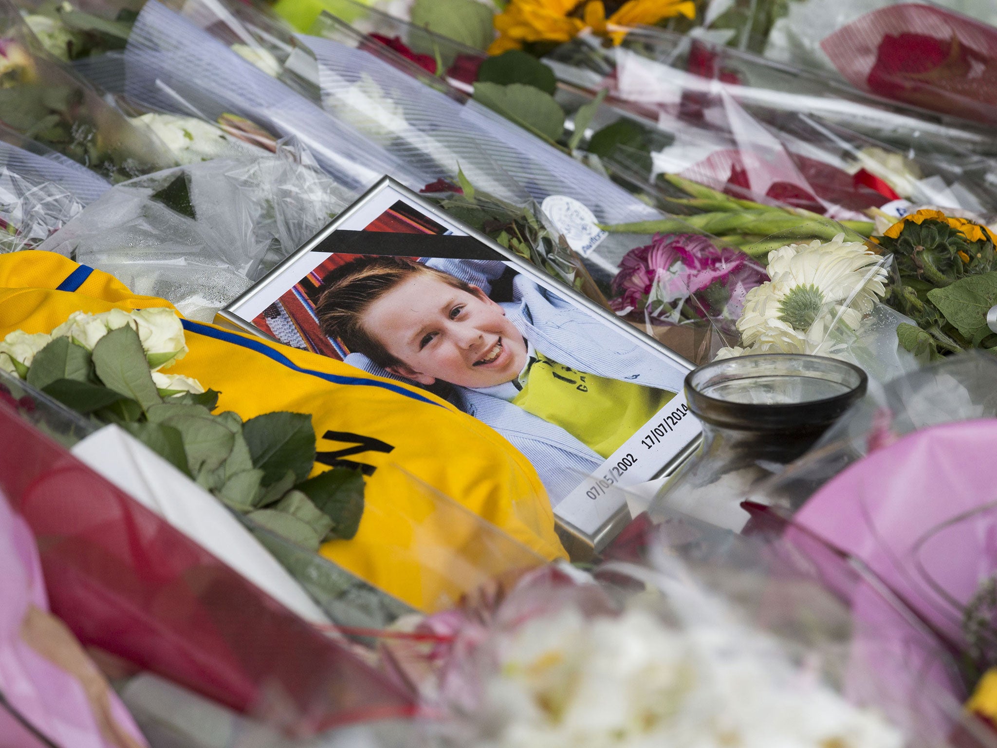 A portrait of a young victim lies at a makeshift memorial for the passengers aboard doomed flight Malaysia Airlines MH17 at Schiphol Airport in Amsterdam