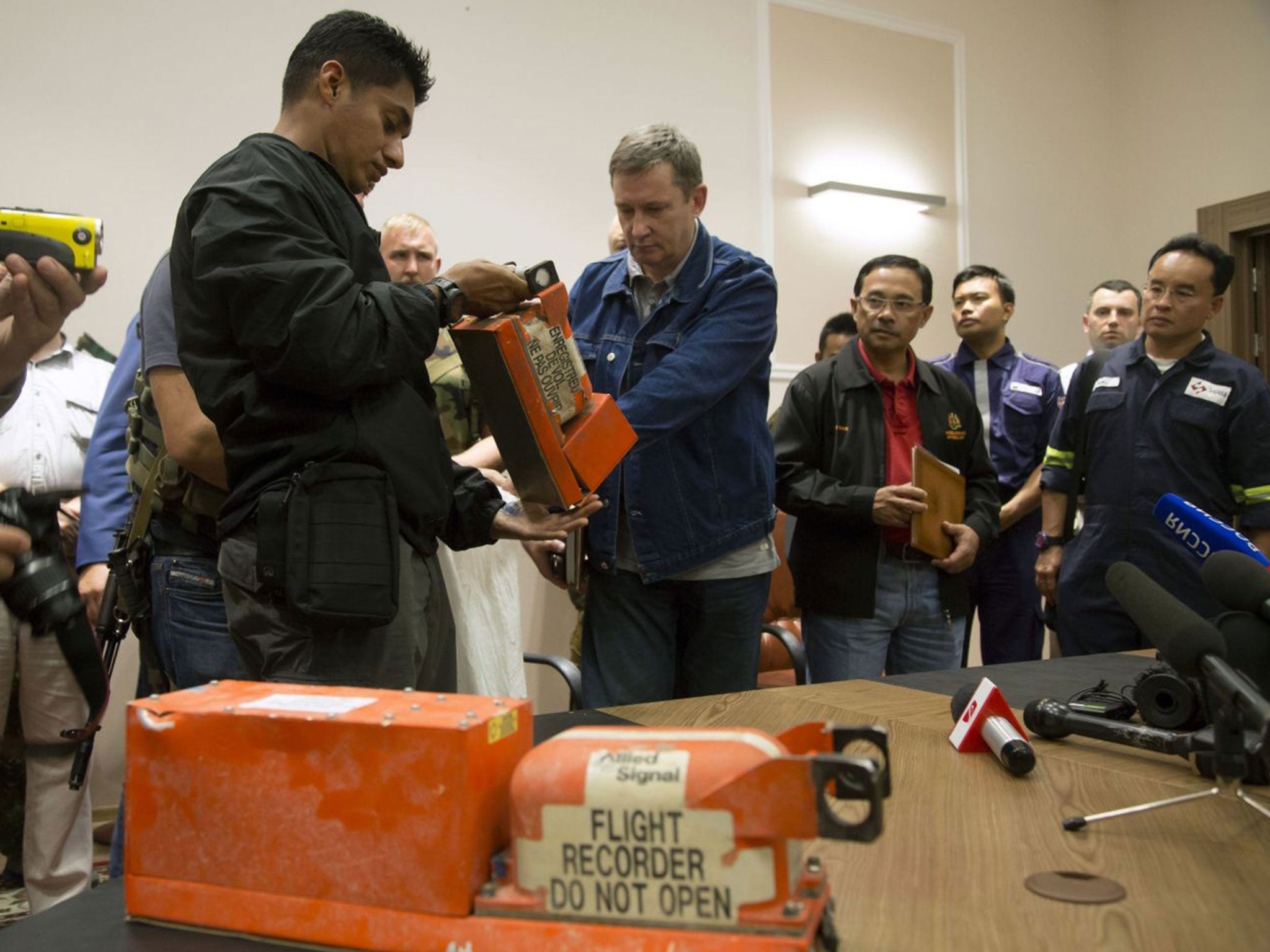 A Donetsk People's Republic official, right, hands over a flight recorder to a Malaysian investigator
