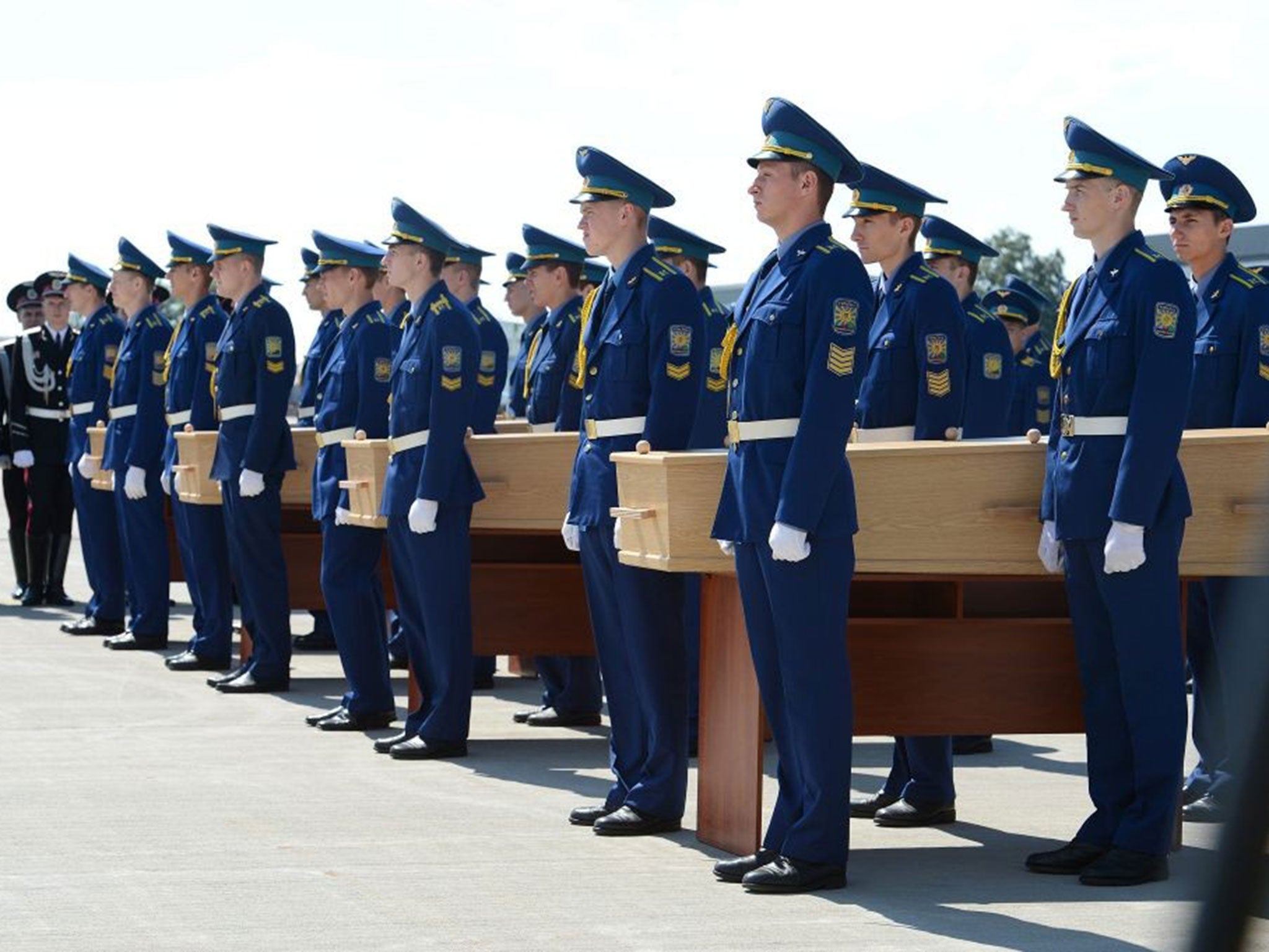 Four coffins with the remains of a victim of the Malaysia Airlines flight MH17 are carried to a military plane during a ceremony on the airport of Kharkiv, Ukraine, 23 July 2014.