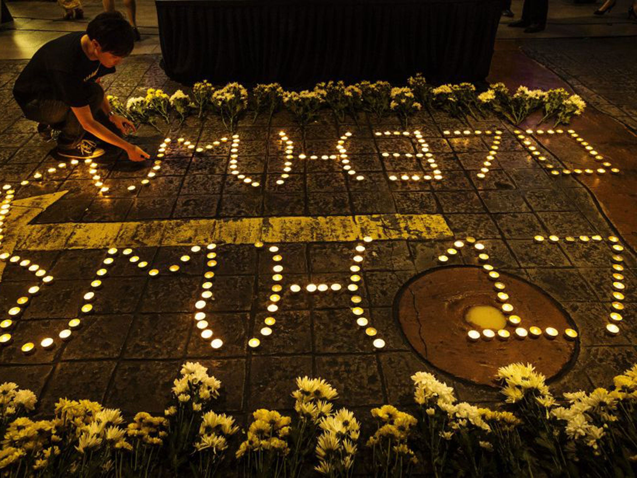 A Malaysian man lights up candles during a vigil in remembrance for passengers and crew of the Malaysian Airline flight MH370 & MH17 in Petaling Jaya near Kuala Lumpur, Malaysia
