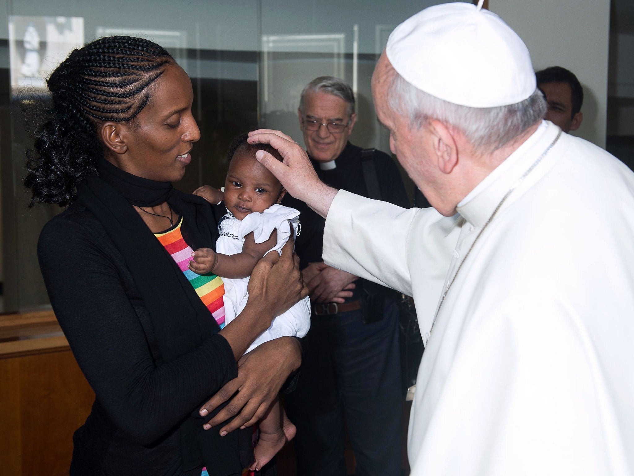 A handout photo released by the Osservatore Romano and taken on July 24, 2014 shows Pope Francis greeting Sudanese Christian Meriam Ibrahim and her daughter Maya during a private audience at the Vatican