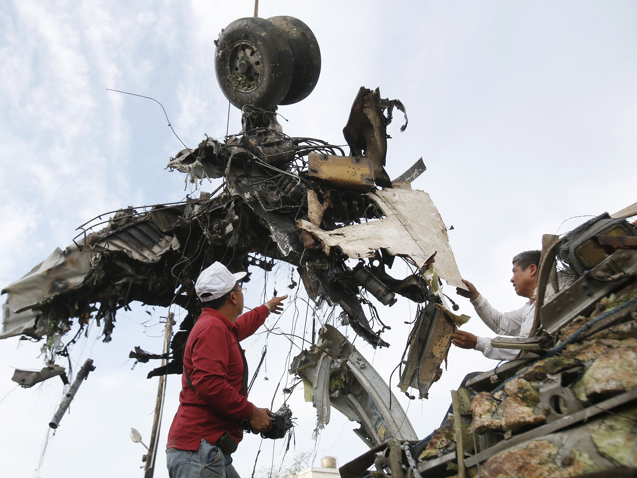 Emergency workers remove the wreckage of crashed TransAsia Airways flight GE222 on the outlying island of Penghu