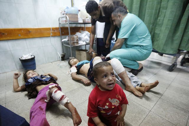 Palestinian children, wounded in an Israeli strike on a compound housing a U.N. school in Beit Hanoun, in the northern Gaza Strip, cry as they lay on the floor at the emergency room of the Kamal Adwan hospital in Beit Lahiya 