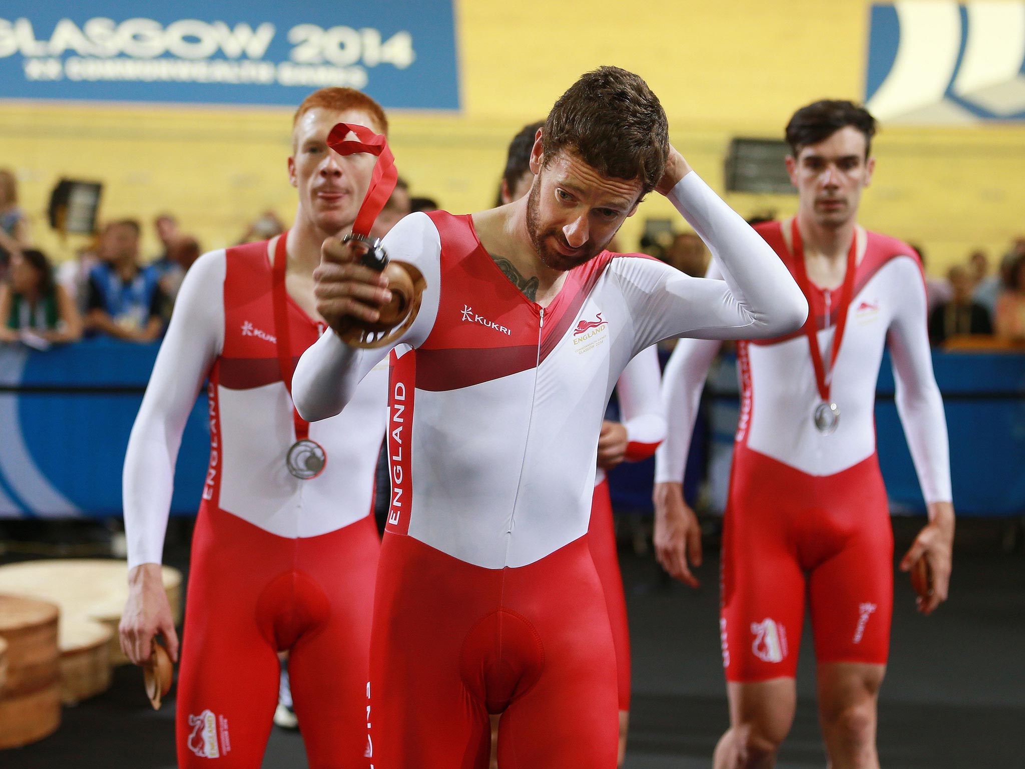 Sir Bradley Wiggins removes his silver medal after the podium ceremony for the men’s 4,000m team pursuit in Glasgow yesterday