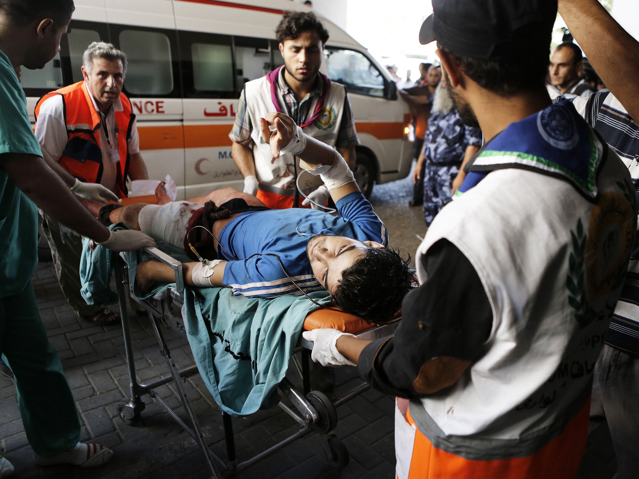 A Palestinian wounded in an Israeli strike on a compound housing a UN school in Beit Hanoun, in the northern Gaza Strip, flashes the V-sign for "Victory" as he arrives on a stretcher at the al-Shifa hospital in Gaza City