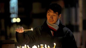 A man lights a candle as family and friends attend a multi-faith service at St. Paul's Cathedral in Melbourne for those who lost their lives on Malaysia Airlines flight MH17  