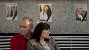 A couple is backdropped by pictures of victims of the MH17 air crash during a memorial concert in Kharkiv, Ukraine 
