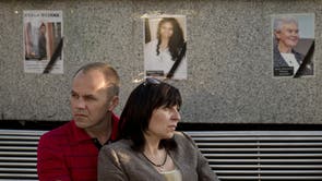 A couple is backdropped by pictures of victims of the MH17 air crash during a memorial concert in Kharkiv, Ukraine