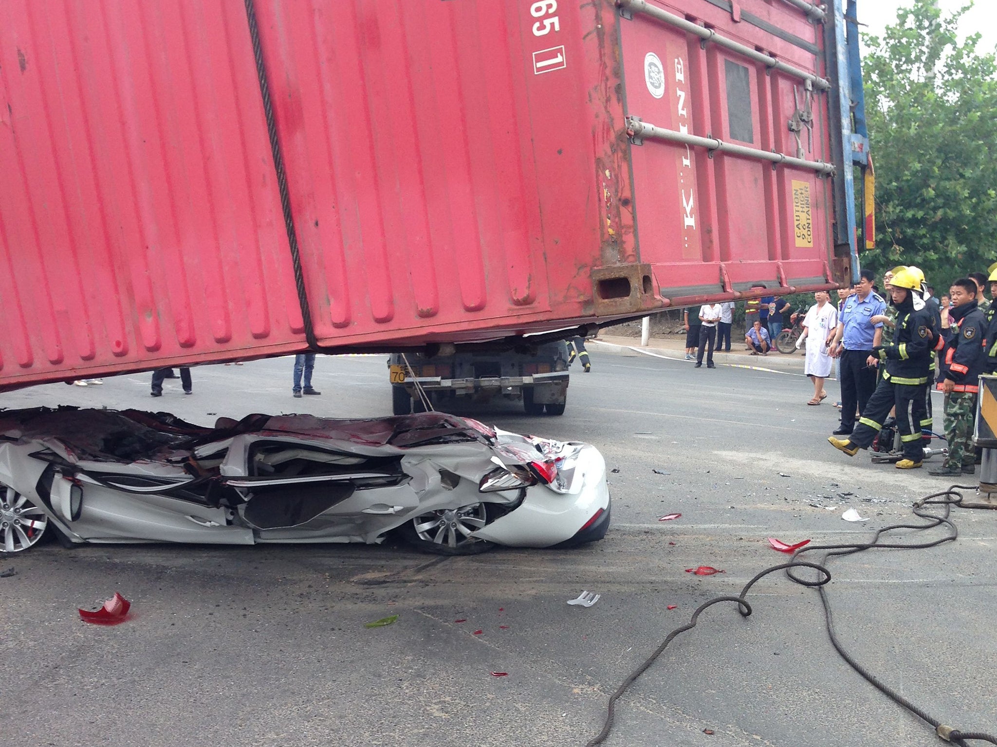 The container is lifted off the flattened car