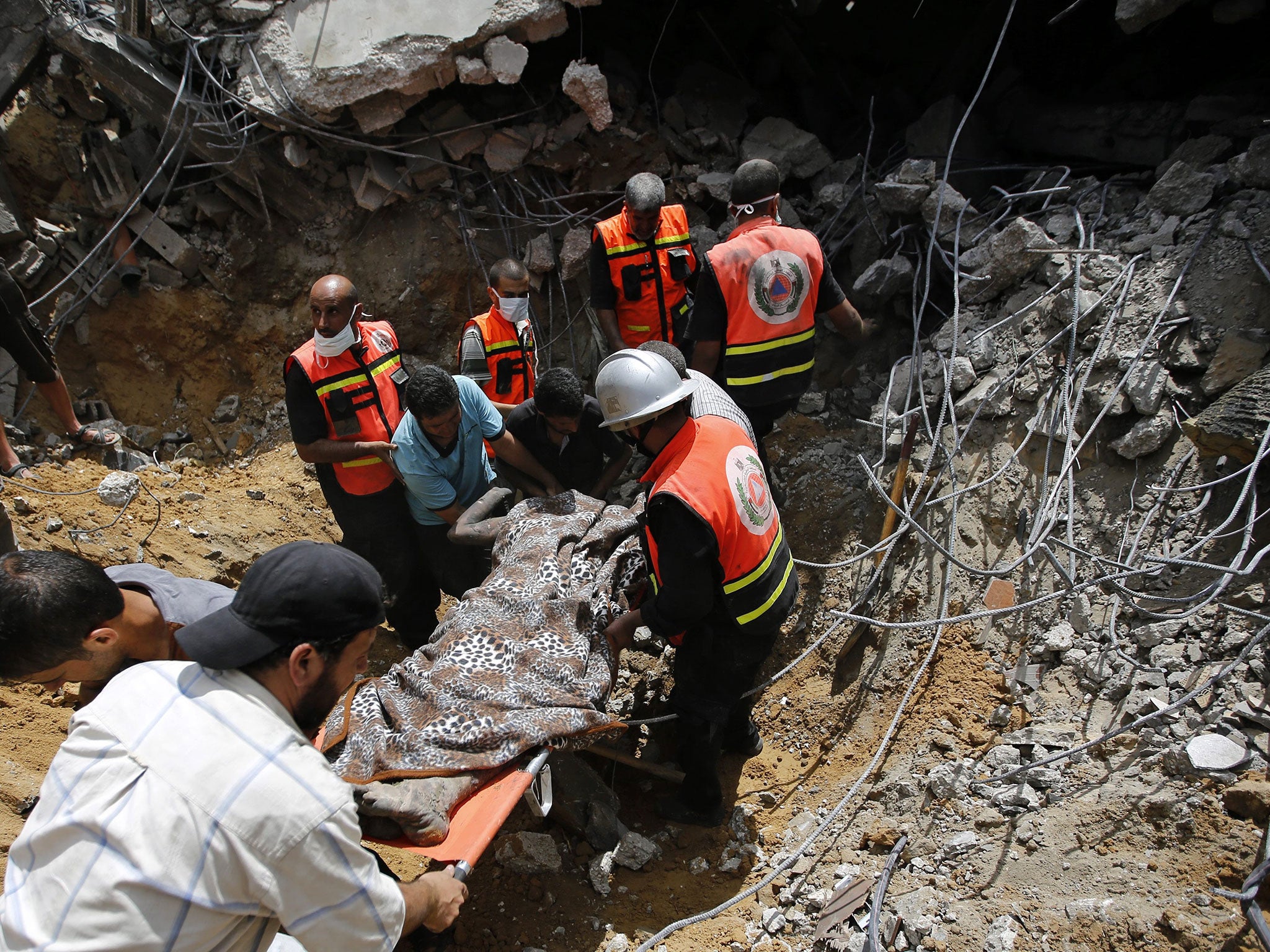 Medics recover a body from a destroyed house in Khan Younis