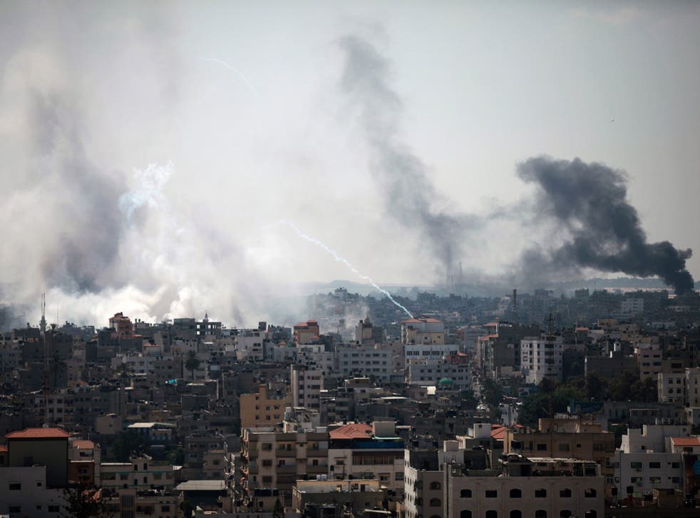 Smoke rises after Israeli tanks shell the Shujaiya neighbourhood during a military operation in the east of Gaza City, 27 July 2014