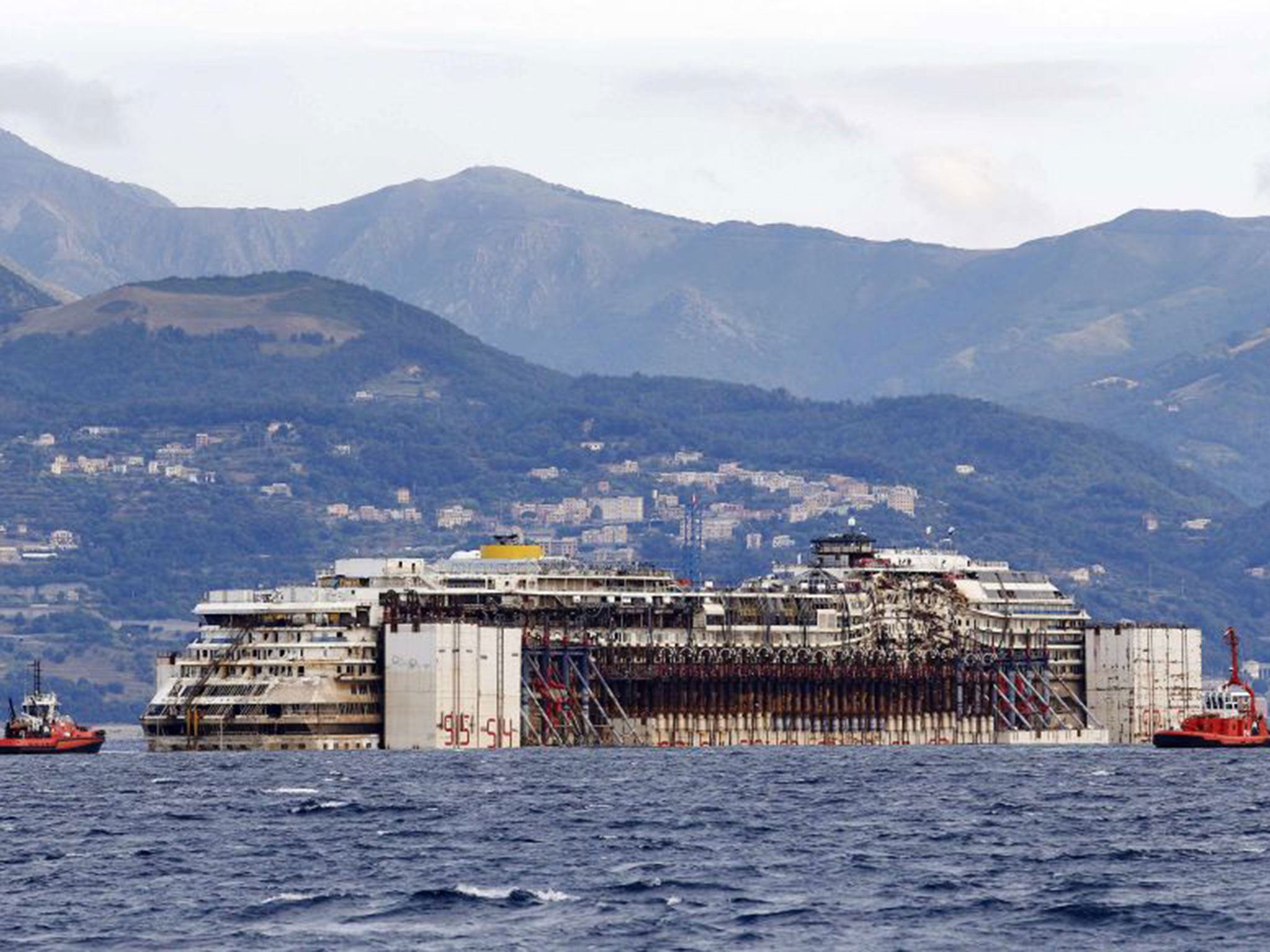 The Costa Concordia being towed into Genoa's port just nine years after it was launched to much fanfare in 2005