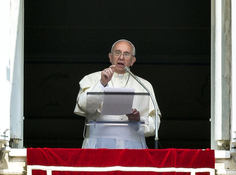Pope Francis delivers a speech from the window of his apartment during his Sunday Angelus prayer in St. Peter's Square at the Vatican on July 27, 2014