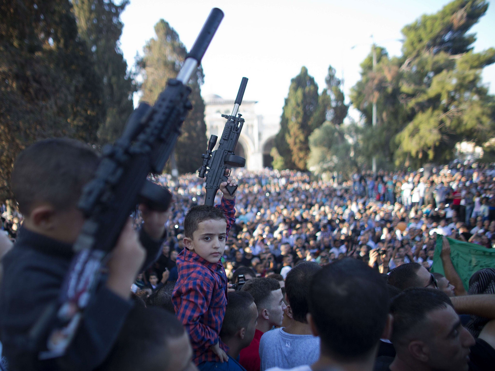 Palestinian children hold up plastic guns during a demonstration against Israel's military offensive on the Gaza Strip following Eid Al-Fitr prayers on July 28, 2014, 2011 in front of the Dome of Rock at al-Aqsa mosque compound, Islam's third most holy si