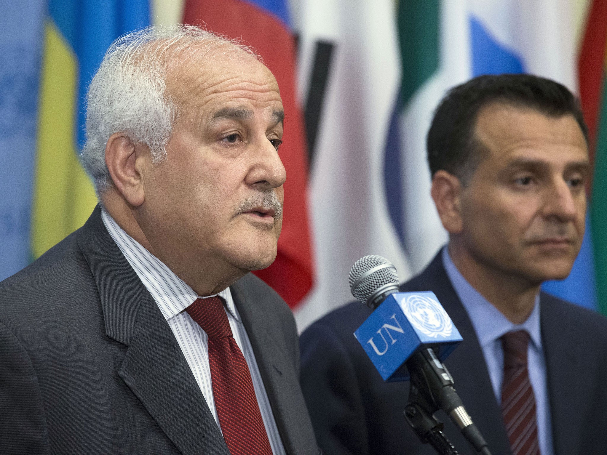 Palestinian UN ambassador Riyad Mansour, left, speaks following a meeting of the Security Council early on Monday, 28 July