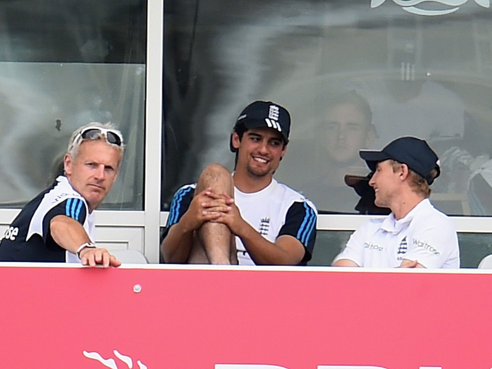 Alastair Cook smiles on the balcony as he speaks with Peter Moores and Joe Root