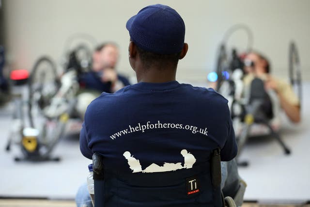 Amputee Corie Mapp watches as other wounded servicemen use some of the exercise machines in the new Help for Heroes' Tedworth House rehabilitation centre for wounded servicemen and women during a press preview day on October 18, 2012 in Tidworth, England.